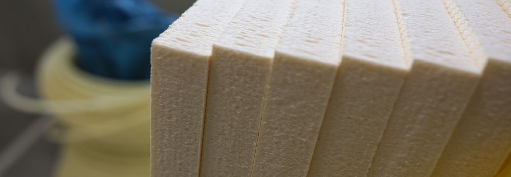 Ein Stapel cremefarbener Dämmplatten aus Hartschaum in der Nahaufnahme.